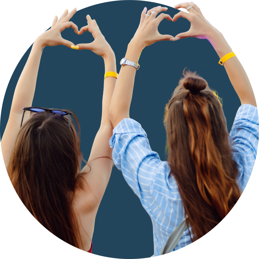 women making heart hands at concert